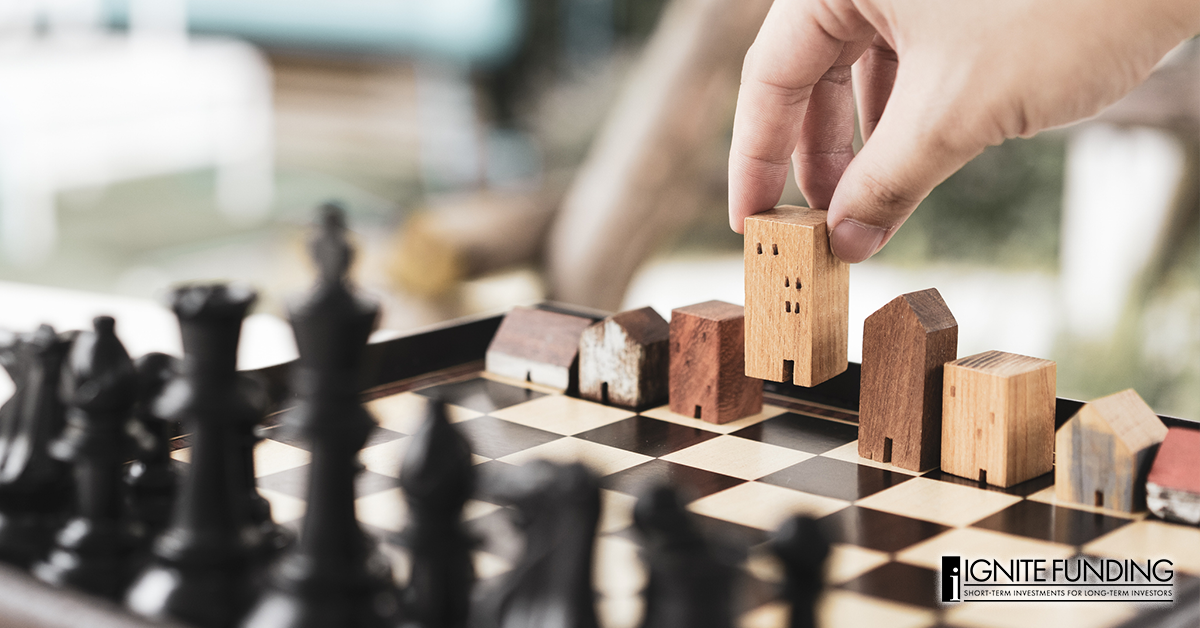 man working on laptop computer with icons representing real estate investment loans