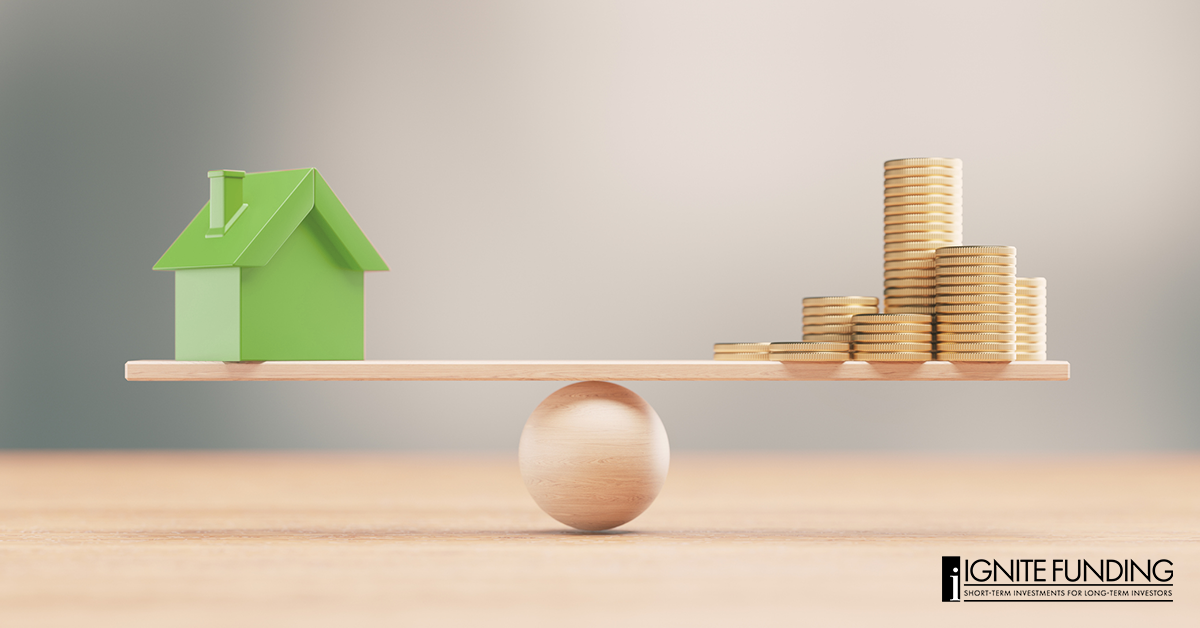 man working on laptop computer with icons representing real estate investment loans